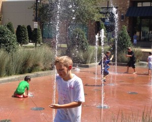 Kids play in the geysers Friday afternoon at The Shops at Highland Village.