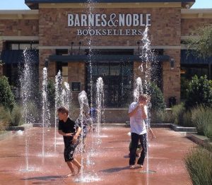 Kids play in the geysers Friday afternoon at The Shops at Highland Village.