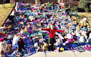 Sadie Keller of Lantana standing in front of the 1,276 toys she collected for kids in the hospital.