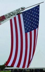 A huge American flag hung from a pole extending from a Flower Mound Fire Department truck. (Photo by Dru Murray.)