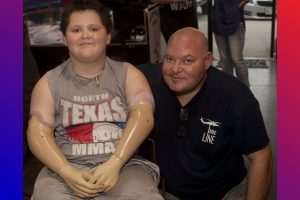 Memphis Lafferty, pictured with his father, Chris, received the gift of prosthetic hands to help him enjoy life to its fullest. (Photo by Helen’s Photography)