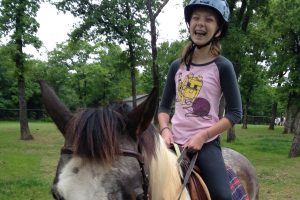 Kathryn, a client of Unbridled Horse Therapy in Flower Mound, enjoys her time in the saddle.