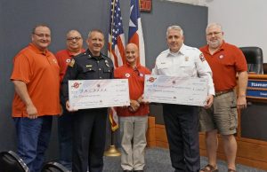 During the Flower Mound Town Council meeting on July 18, the Summit Club of Flower Mound presented checks for $1,000 to the FMPD and FMFD. Pictured, left to right, are: Summit Cub members Perfecto Solis, Paul Stone, Al Picardi and Claudio Forest; with FMPD Chief Andy Kancel and FMFD Chief Eric Greaser holding their checks. (Photo courtesy of Molly Fox)