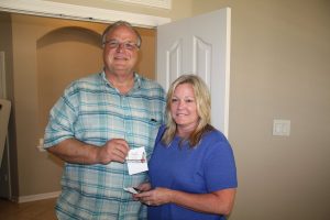 Argyle Fire Chief Mac Hohenberger and wife, Karla, accept a gift card from Brightside Boutique in The Shops at Highland Village to help replace the clothes they lost in a house fire on June 21st.