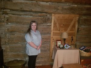 Tami Lynch Peevey standing in front of the log cabin wall in her living room. (Courtesy Photo: Ronnie Peevey)