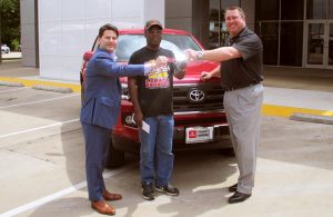 Don Moody (center) bought a ticket for the Community Support Raffle and won a 2016 Toyota Tacoma from Toyota of Denton.