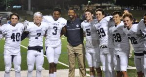 Ross Roby (center) with some of Liberty’s football players at a recent game.