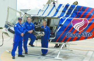 Flight paramedics Dustin Brewer and Jon Whitener and flight nurse Peg Chappell stand next to the Bell 407GX helicopter at CareFlite’s Denton base that helps them perform life-saving missions. (Photo by Dru Murray)