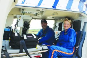 Despite tight quarters on their helicopter, Flight Paramedic Dustin Brewer and Flight Nurse Peg Chappell are all smiles because they know they have the equipment they need right at hand to help them save lives. (Photo by Dru Murray)